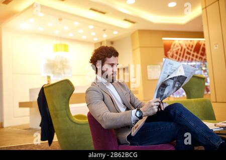 young serious man concentrated on reading breaking news. close up side view photo. gossip, man reading news, information. hobbu, interest , close up s Stock Photo