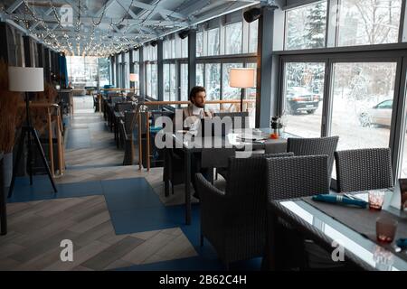 young serious man thinking about his problems, making up plan, ideas to make business prosperous. Stock Photo