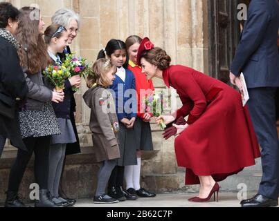 Duchess of Cambridge speaks to school children as she leaves after the Commonwealth Service at Westminster Abbey, London on Commonwealth Day. The service is the Duke and Duchess of Sussex's final official engagement before they quit royal life. Stock Photo