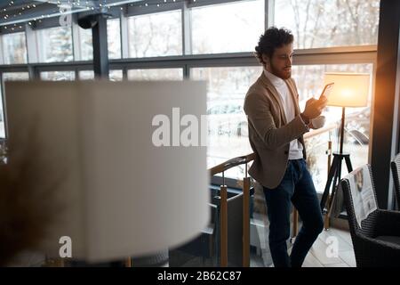 young attractive man sending message to girlfriend, love, relationship, pleasant businessman consulating clients online. close up side view photo Stock Photo