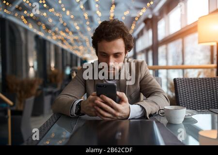 man is addicted to gadget, bearded man watching vebinar, workshop, close up photo.man holding mobile phone, looking at the screen , photos Stock Photo