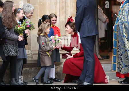 Duchess of Cambridge speaks to school children as she leaves after the Commonwealth Service at Westminster Abbey, London on Commonwealth Day. The service is the Duke and Duchess of Sussex's final official engagement before they quit royal life. Stock Photo