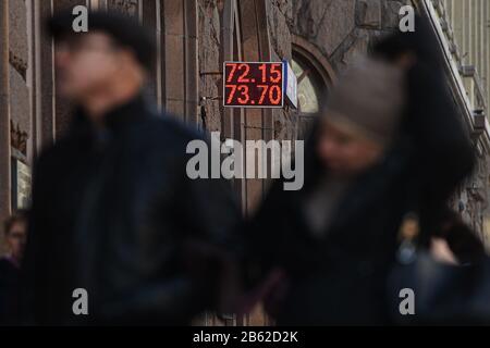 Moscow, Russia. 9th Mar, 2020. Pedestrians walk past an exchange rate displaying screen in Moscow, Russia, on March 9, 2020. Russia's ruble depreciated against the U.S. dollar to about 73 rubles per dollar on the international market on Monday, the weakest level since March 2016, trading data showed. Credit: Evgeny Sinitsyn/Xinhua/Alamy Live News Stock Photo