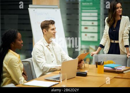 young cheerful successful business partners in a meeting sitting at table discussing a new project, close up photo.new ideas, plans. happiness Stock Photo