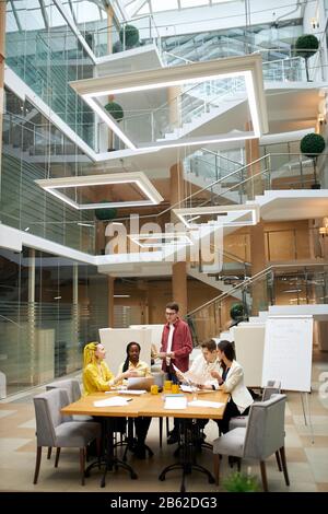 young awesome talented designers brainstorming in the office with modern interior. full length vertical shot.teamwork, partnership Stock Photo