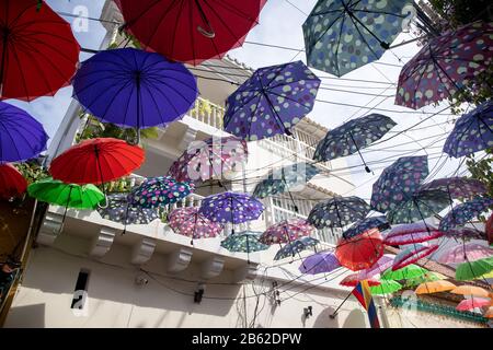 Umbrellas hang above the streets in Getsemani along with the graffiti on many walls there is a wonderful ambience to this part of Cartgena. Stock Photo