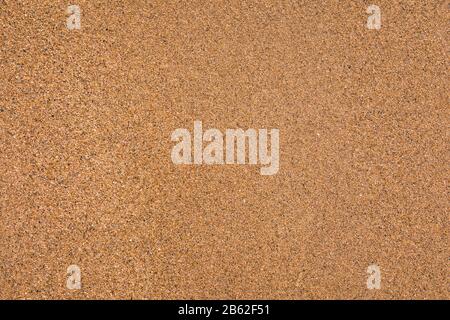 Sand surface and background. Sand Texture. Brown sand. Background from fine sand. Sand background. Closeup of sand pattern of a beach in the summer. Stock Photo