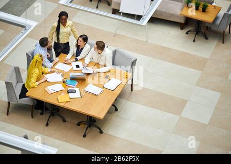 african leader giving recommendation to her employees, management. marketing, top view photo. copy space Stock Photo