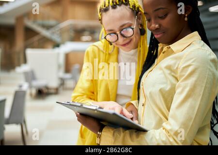young aweso me women enjoying their profession. close up photo. women analyzing documents. blurred background. friendship, cosultation Stock Photo