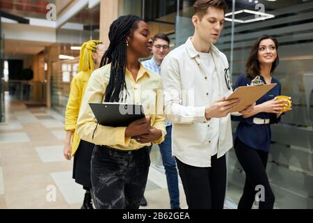 journalists are rushing to the conference, young attractive people discussing news, project, plans , ideas. busy atmosphere at office , job, professio Stock Photo