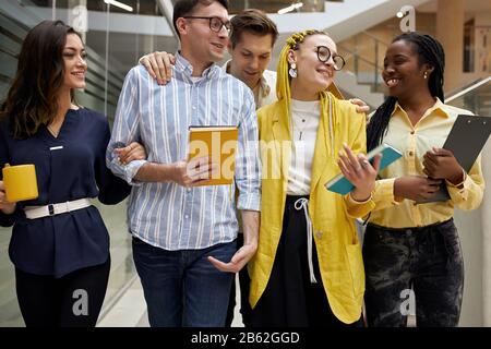 awesome students are happy as they have passed exams, pleasant coworkers having fun in the office, having break time Stock Photo