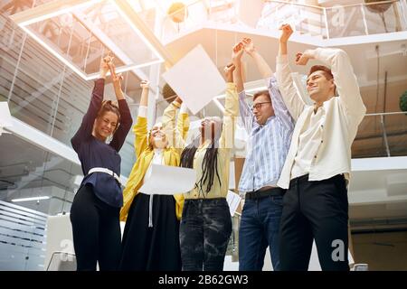 excited cheerful business team celebrate corporate victory together in office, happy overjoyed professionals group rejoice at victory Stock Photo