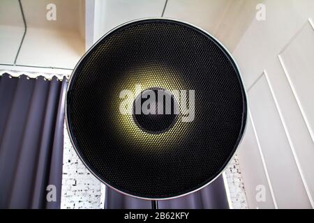 Gridded beauty dish mounted on a flash unit on a lighting workshop. Interior studio with a pulsed light source Stock Photo