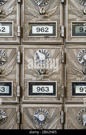 close up of metal post office boxes with eagle design and combination locks Stock Photo