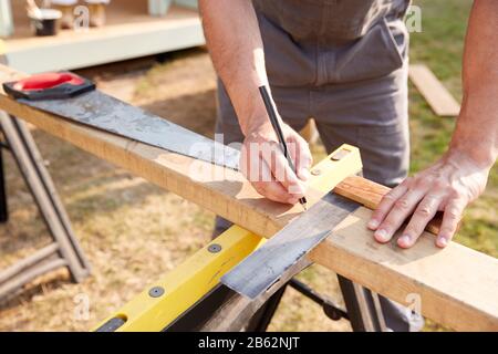 Close Up Male Carpenter Measuring Wood Using Set Square Outdoors Stock Photo