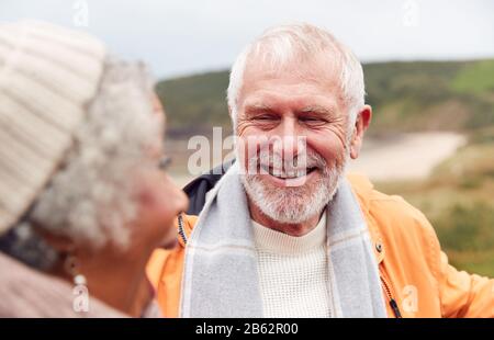 Close Up Of Loving Active Senior Couple Taking A Break As They Walk Along Coastal Path In Winter Stock Photo