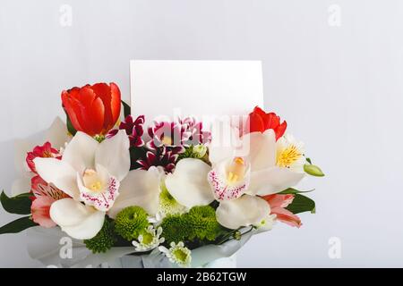 Flowers mock up congratulation. Congratulations card in bouquet flowers on white background. Blank card with space for text, frame mockup. Spring Stock Photo