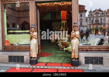 Entrance to a colorful Thai gift shop and massage parlor decorated with statues of Asian women in national costumes Stock Photo