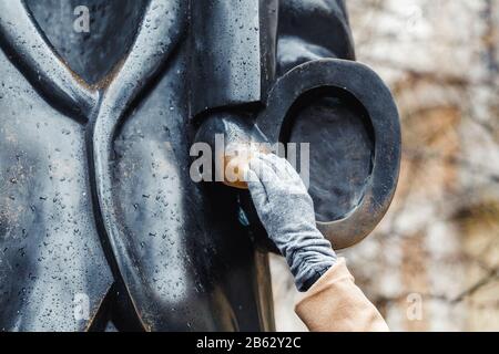 Woman touching the sculpture fragment and rub it Stock Photo