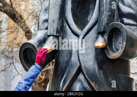 Woman touching the sculpture fragment and rub it Stock Photo