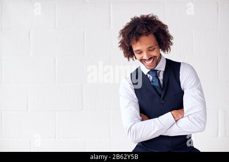 Confident Young Businessman Wearing Suit Standing Against White Studio Wall Stock Photo