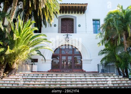 ornate arched entrance to the historic Santa Barbara County courthouse in California framed by lush palm trees on a sunny day Stock Photo