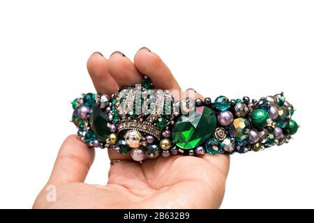 The diadem or tiara with precious green stones isolated in the woman's hand Stock Photo