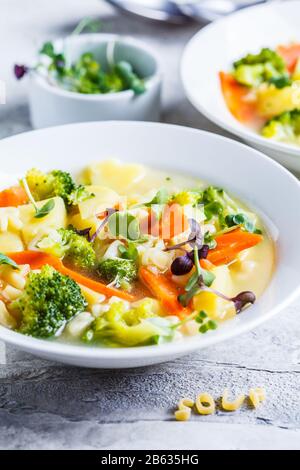 Healthy kids alphabet soup with vegetables and noodle letters in white plates. Baby food concept. Stock Photo