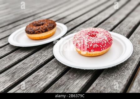 two delicious chocolate and pink donuts on wooden background Stock Photo