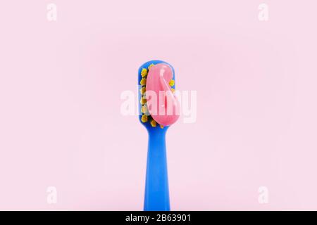 Bright toothbrush with pink paste close-up on a pink background. Stock Photo