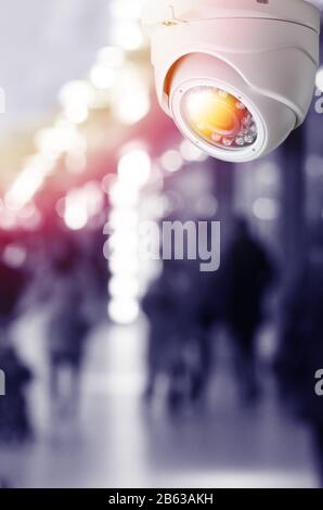 Cctv camera security system on a ceiling of a shopping mall blurred background. Toned image with light flare mock up Stock Photo