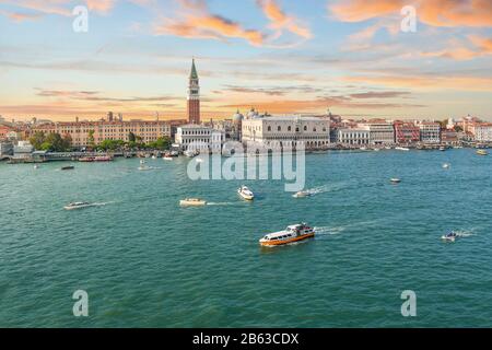 Sunset aerial view of the Grand Canal and Giudecca Canal converging in front of Piazza San Marco, Campanile tower and Doge's Palace in Venice, Italy
