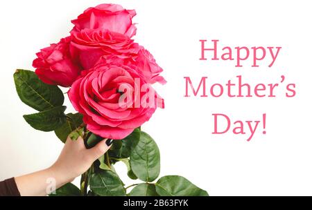 Happy Mothers Day text on white background with flower bouquet of pink roses in female hand. Flower delivery, Congratulations for Mom, women, mother Stock Photo