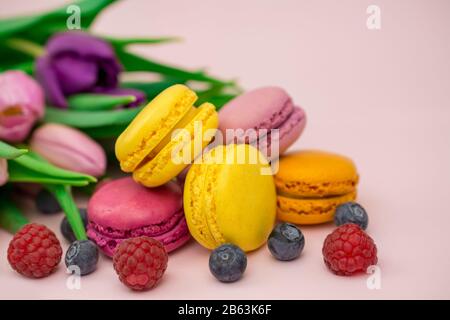 colorful biscuits macaroons blueberry , raspberry , fresh mint on yellow background Stock Photo