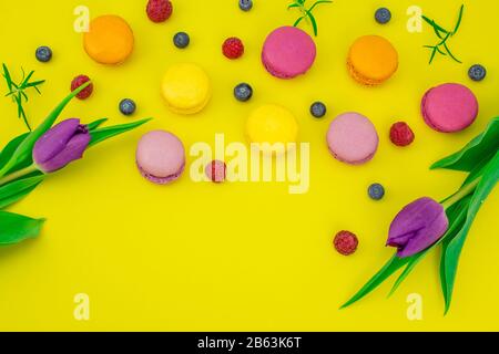 colorful biscuits macaroons blueberry , raspberry , fresh mint on yellow background Stock Photo