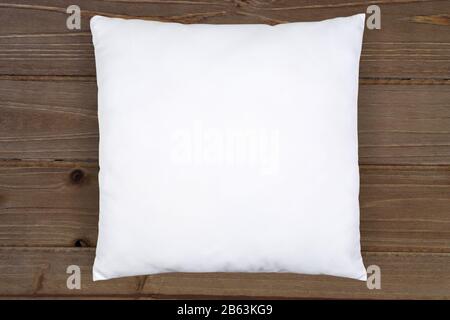 White Square Throw Pillow Mockup on a Rustic Brown Wood Background. Stock Photo