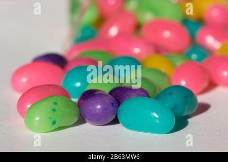 a pile of colourful jelly beans spilled onto a white surface Stock Photo