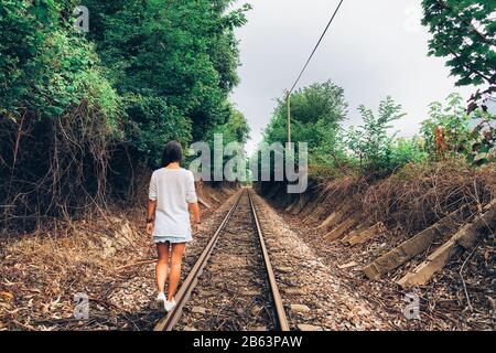 Girl balancing on the train rail thinking on future Stock Photo