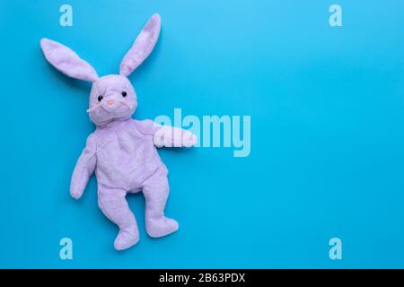 Rabbit toy on blue background. Copy space Stock Photo