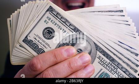 A pile of 100 dollar bills in a man's hands Stock Photo