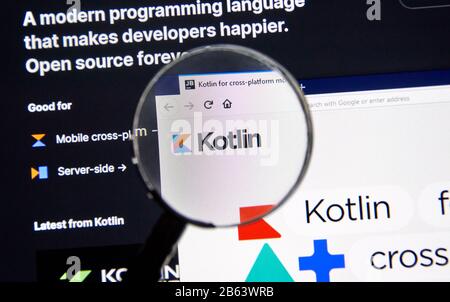 Montreal, Canada - March 08, 2020: Kotlin example code, site and logo under magnifying glass. Kotlin is a modern popular cross-platform, statically ty Stock Photo