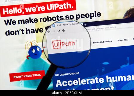 Montreal, Canada - March 08, 2020: UiPath official website and logo under magnifying glass. UiPath is a global software company that develops a platfo Stock Photo
