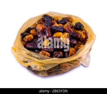 Dried dates in a shopping bag, isolated on white background. Date fruits with different varieties. Stock Photo