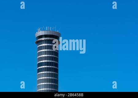 Air traffic control tower in the airport against clear blue sky. Airport traffic control tower for control airspace by radar. Aviation technology. Stock Photo