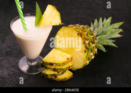 Milkshake with pineapple on a black background. Stock Photo