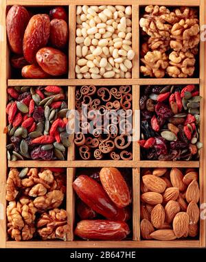 Dried fruits, various nuts and seeds in old wooden box. Top view. Stock Photo