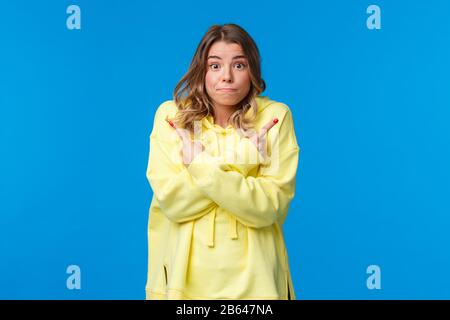 Indecisive and unsure, cute european female teenager making her choices in life, shrugging asking friends opinion, need advice or help as choosing Stock Photo