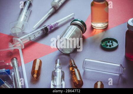 Medicines, syringes, ampules on the table. Medications randomly scattered across the table. Hard work of doctors. Close-up. Selective focus. Without Stock Photo