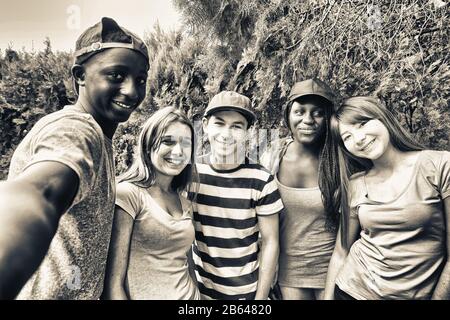 Multi ethnic teenagers smiling outdoor making selfie. Stock Photo