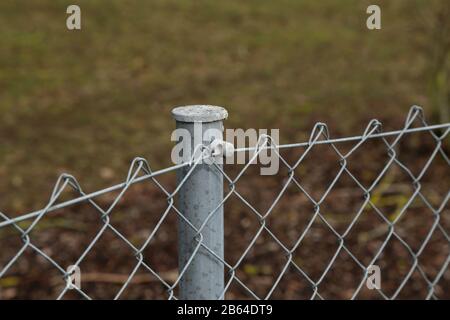 Fence made of metal posts and metal mesh Stock Photo